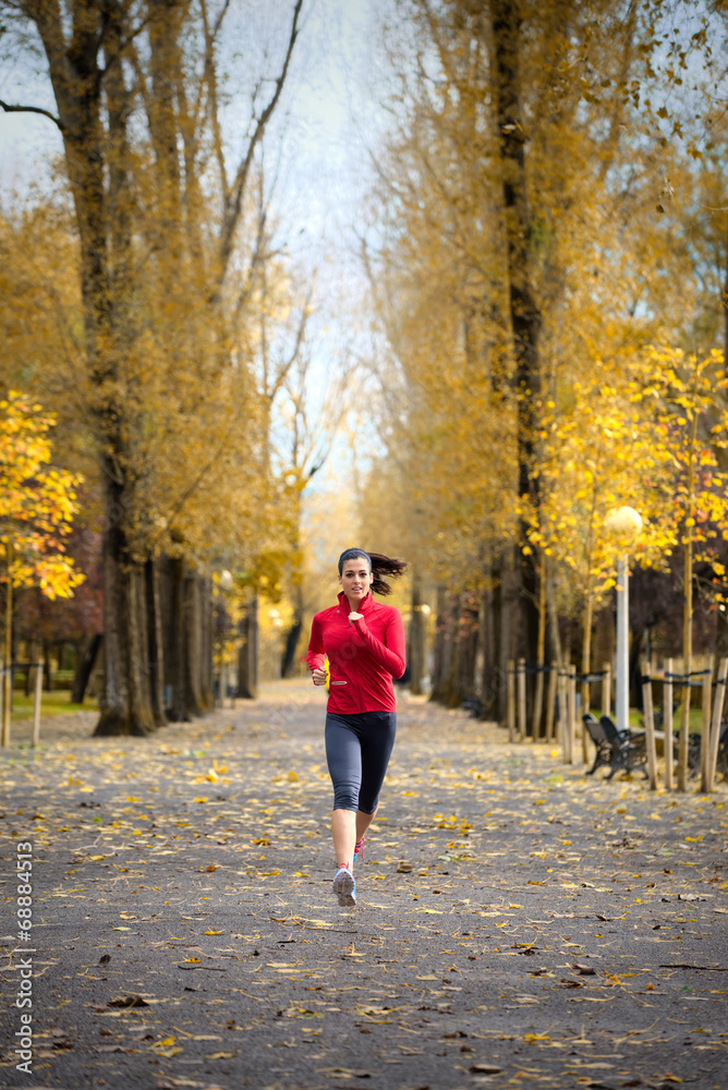 Woman running in autumn park