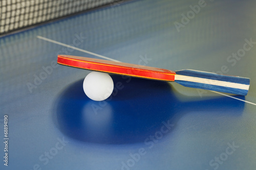 racket, tennis ball on blue ping pong table