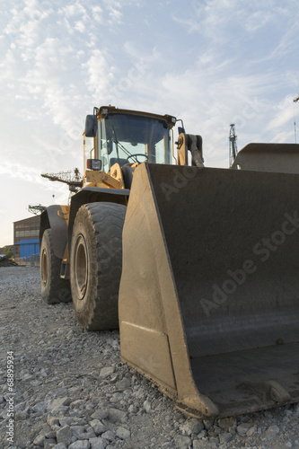 Large bulldozer with the shipyard on the background