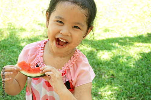 Little girl eating watermelon in summer time