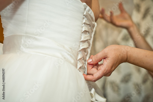 Process of clothing of a wedding dress.