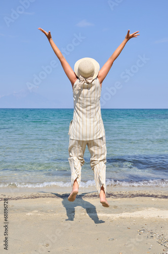 Woman jumping and having fun on the beach