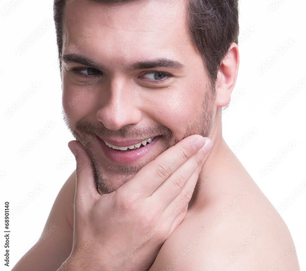 Smiling young man with hand near the face.