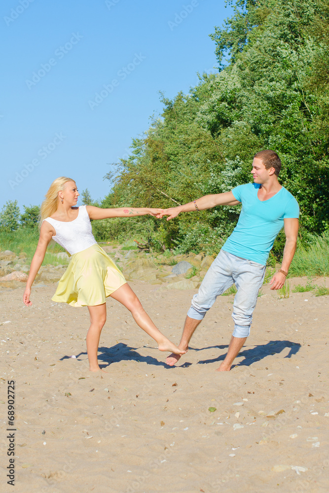 Romantic young couple dancing on the beach.