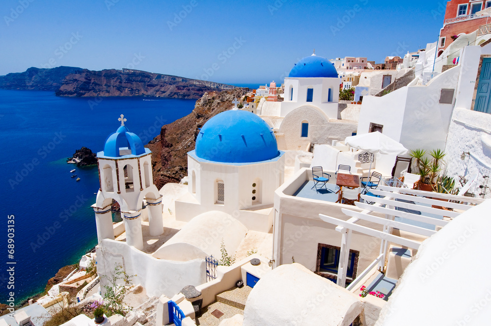 Fototapeta premium Kościół Oia z niebieskimi kopułami na wyspie Santorini, Grecja