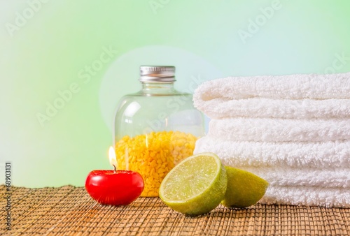 Spa massage with towel stacked,red candle and lime