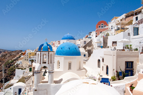 Oia church with blue domes and bell on the Santorini, Greece