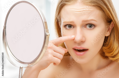 beautiful woman frightened saw in mirror acne and wrinkles