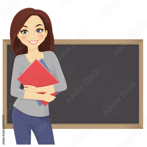 Cute student with books in front of blackboard