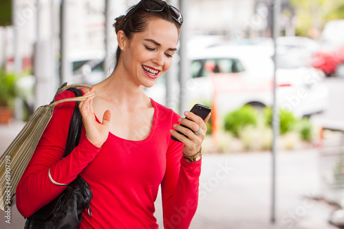 Smiling woman looking at mobile phone