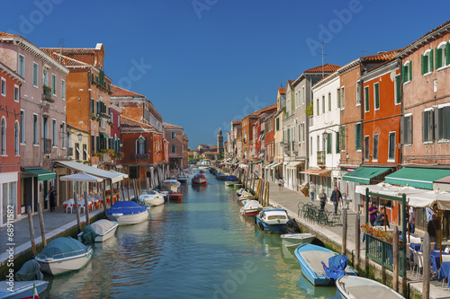 Tela Murano island canal, colorful houses and boats, Italy.