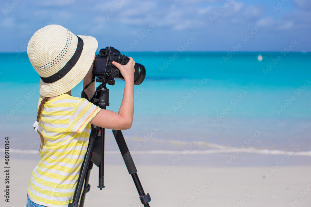 Little girl shooting with camera on tripod during her summer