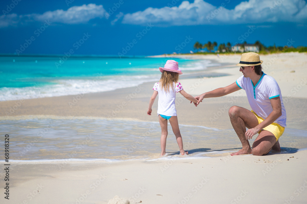 Happy father and his cute little daughter at beach