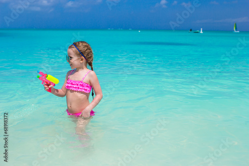 Cute little girl playing with toys during caribbean vacation