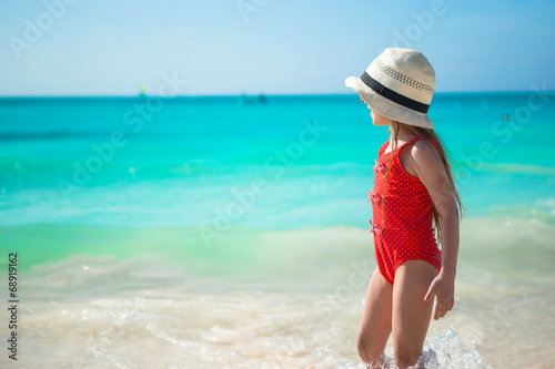 Cute little girl playing in shallow water at exotic beach