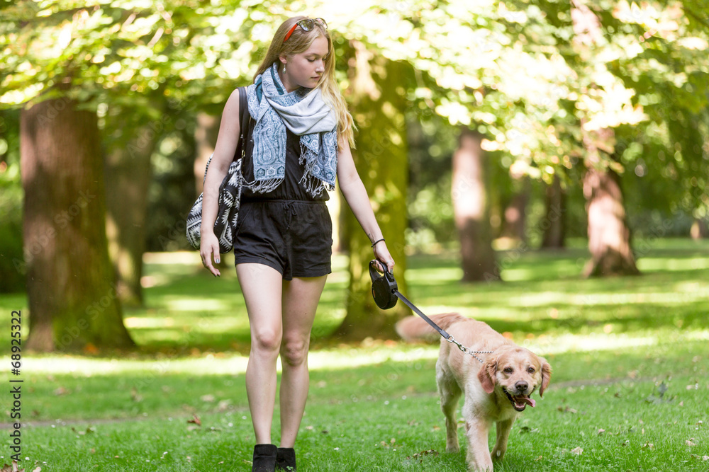 Young woman walking with dog in the park Young woman walking with dog in the park