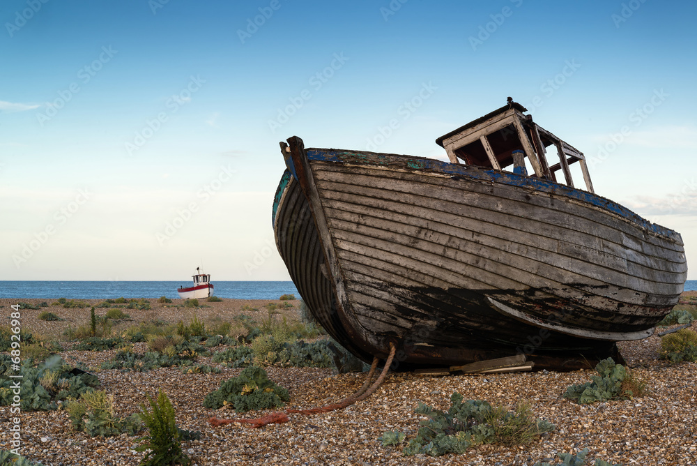 Abandoned fishing boat on beach landscape at sunset
