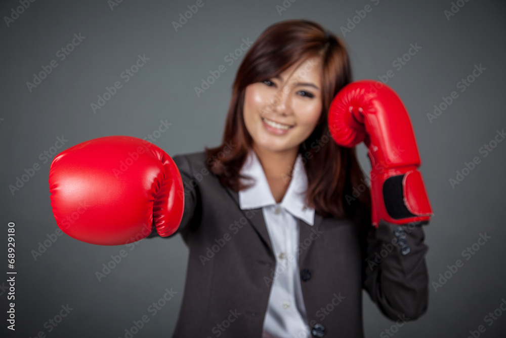 Asian businesswoman punch with boxing glove focus on the glove Asian businesswoman punch with boxing glove focus on the glove