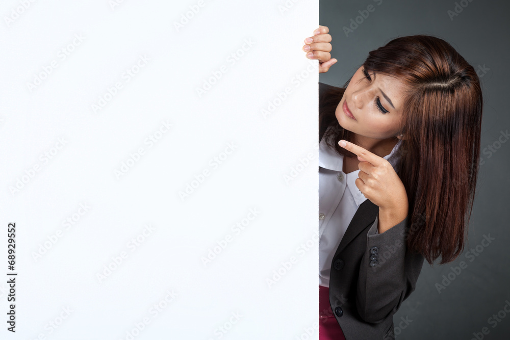 Asian businesswoman stand behind a blank banner , point and loo Asian businesswoman stand behind a blank banner , point and loo