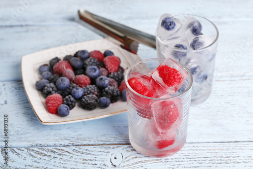 Frozen berries and ice cubes with mint leaves, raspberry and