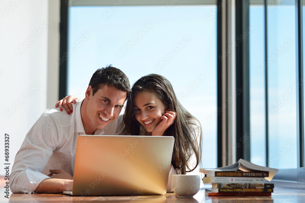 relaxed young couple working on laptop computer at home relaxed young couple working on laptop computer at home