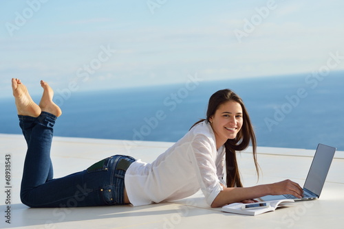 relaxed young woman at home working on laptop computer