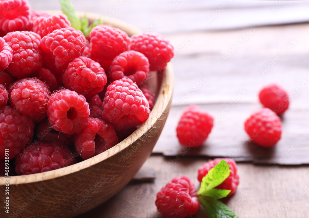 Ripe sweet raspberries in bowl on table close-up Ripe sweet raspberries in bowl on table close-up
