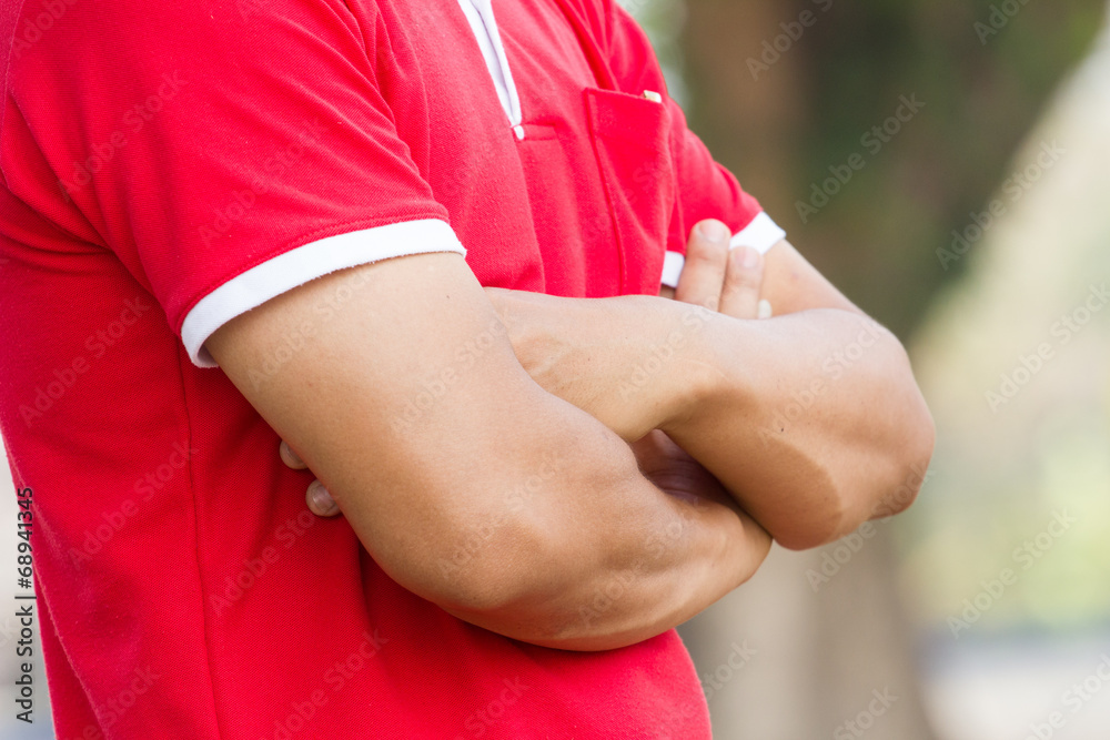 man with arms crossed in a garden