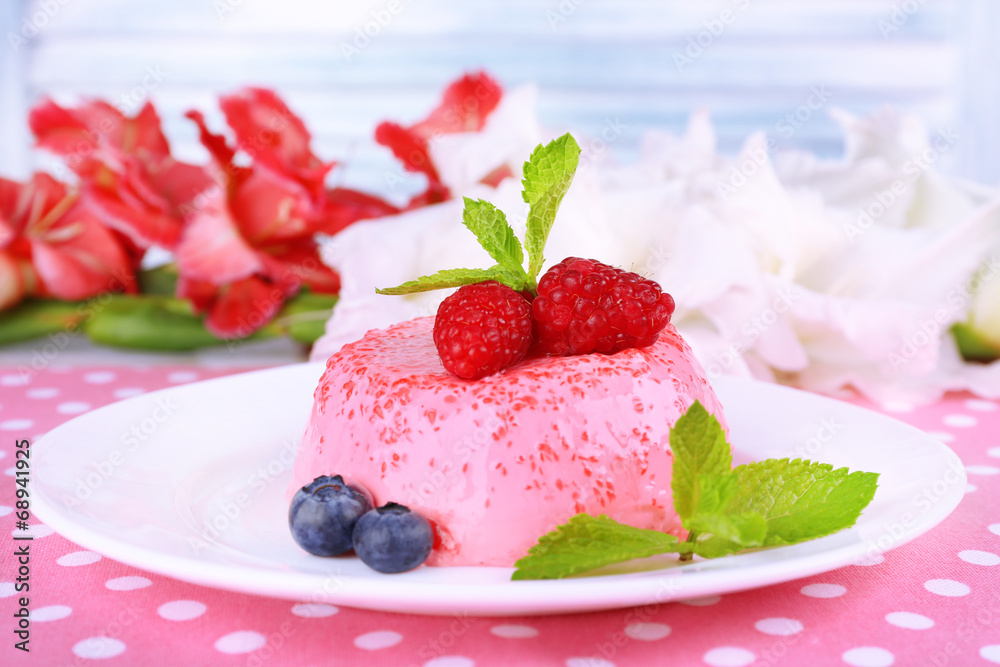 Round shaped cake with berries on plate on polka dot table
