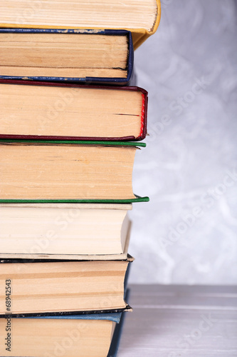 Books on wooden table on light background