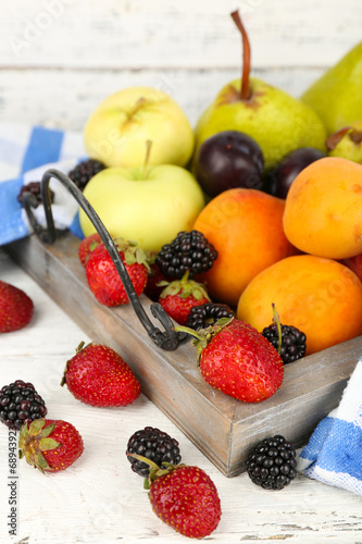 Ripe fruits and berries on table on wooden background