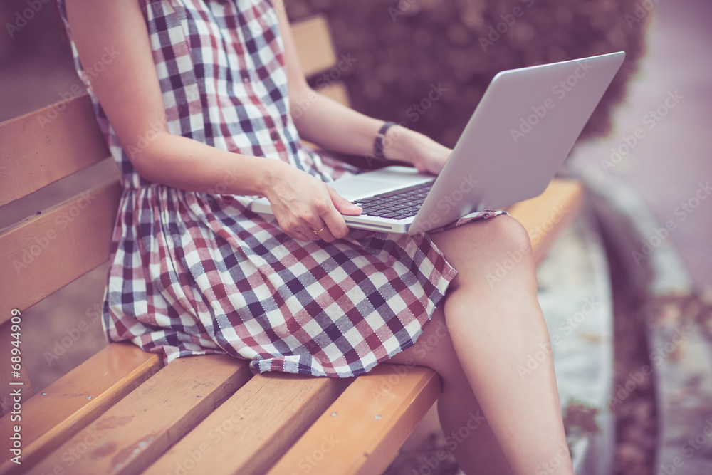 Naklejka premium Woman using laptop indoor.close-up hand