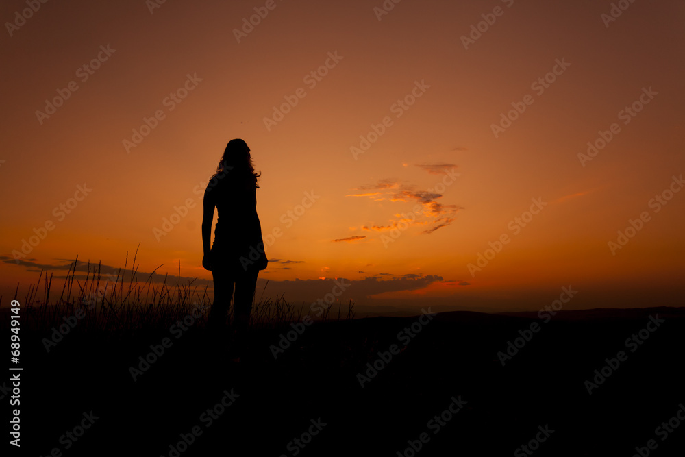Woman silhouette admiring the sunset