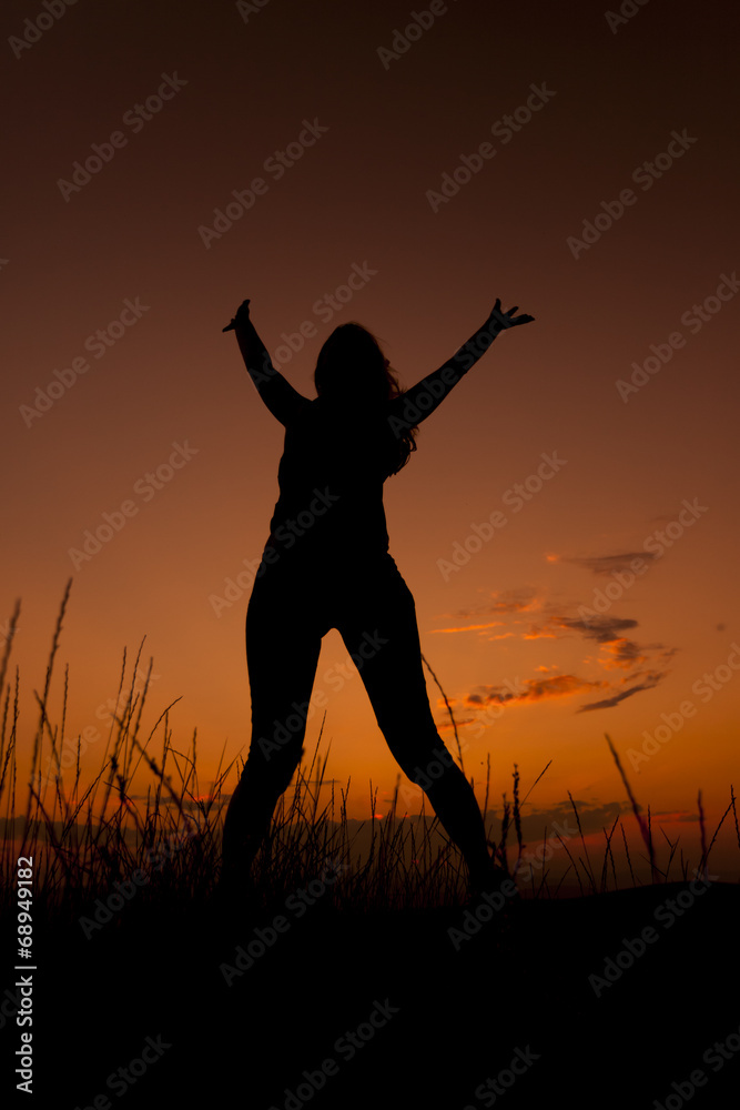 Happy woman jumping. Silhouette in the sunset sky