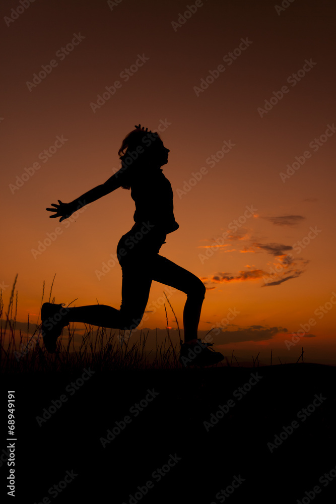 Happy woman jumping. Silhouette in the sunset sky