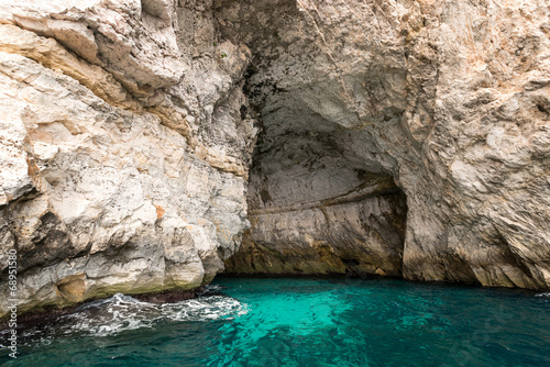 Caves and cliffs at the coast of Gozo Island entrance © nanisimova