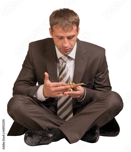 Businessman sitting and hold gold lamp photo