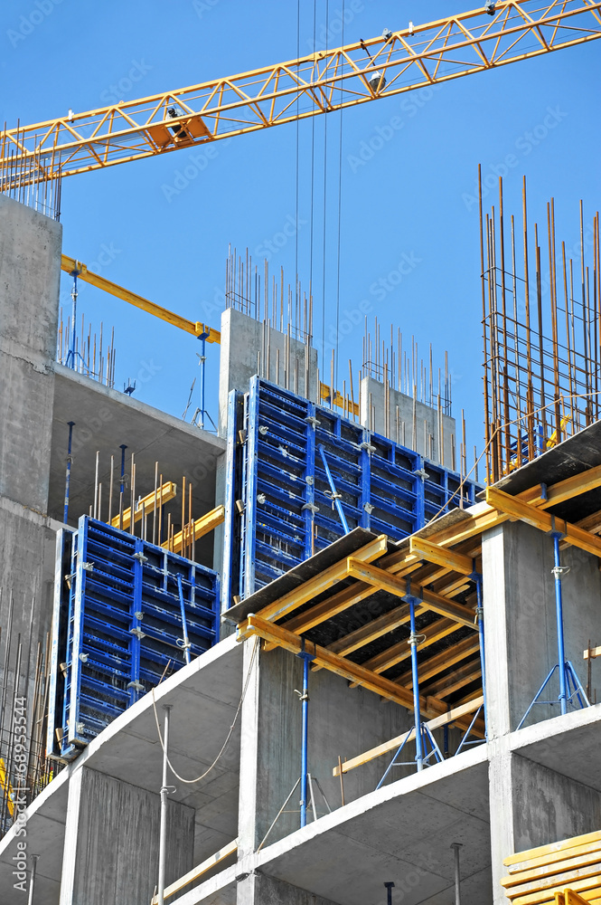 Crane and building construction site against blue sky Crane and building construction site against blue sky