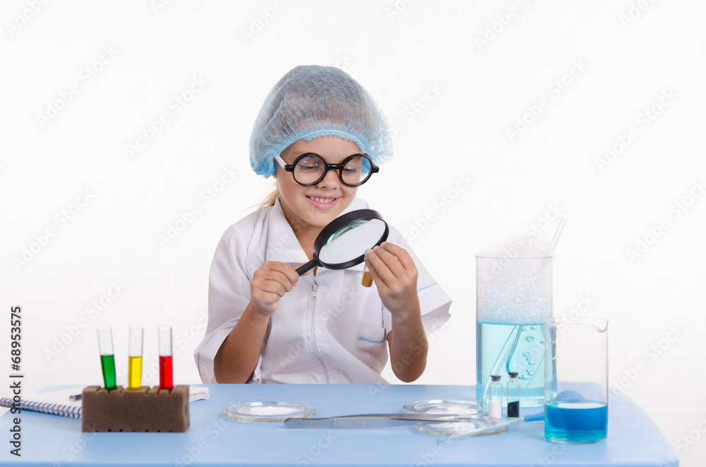 Chemist looking through a magnifying glass on powder Chemist looking through a magnifying glass on powder