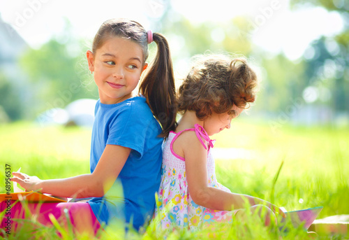 Two little girls are reading books