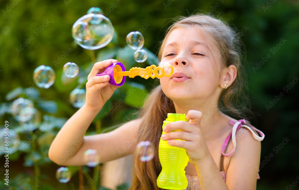 Little girl is blowing a soap bubbles Little girl is blowing a soap bubbles
