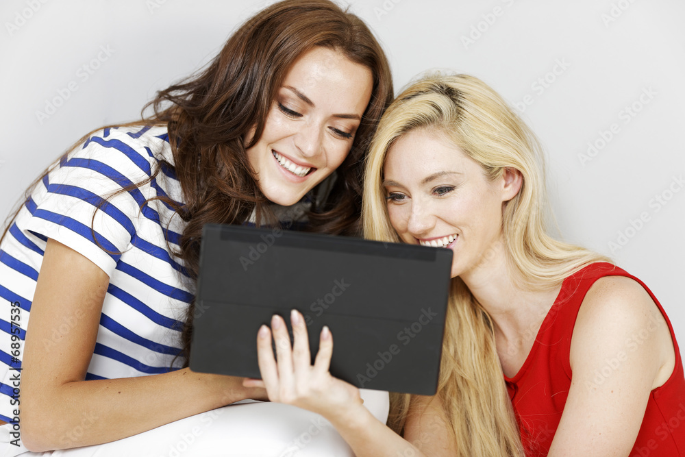 Two friends using a computer tablet Two friends using a computer tablet