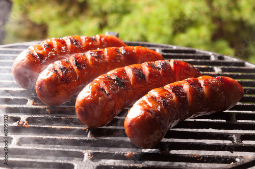 Foto Grilling sausages.