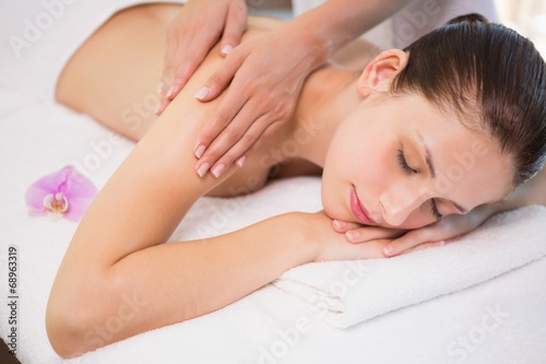 Attractive woman receiving shoulder massage at spa center