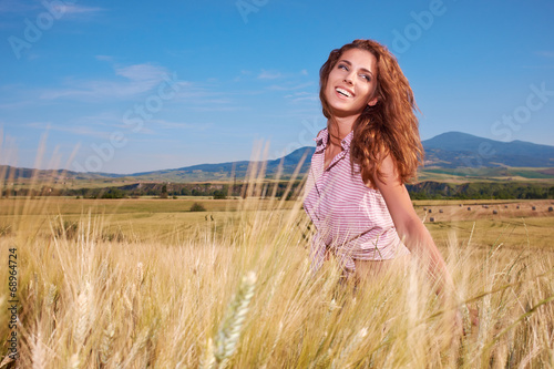 Happy woman in golden wheat