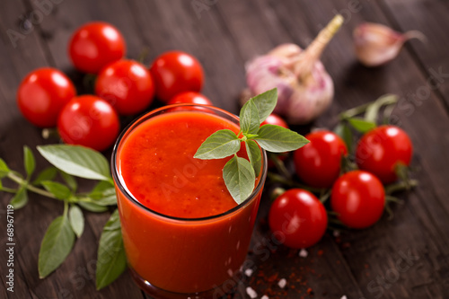 Bild auf Leinwand Glass of tomato juice on old wooden table