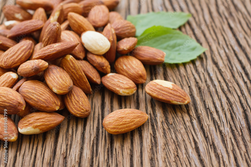 Almonds  with leaf on wooden background