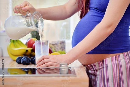pregnant woman pouring milk