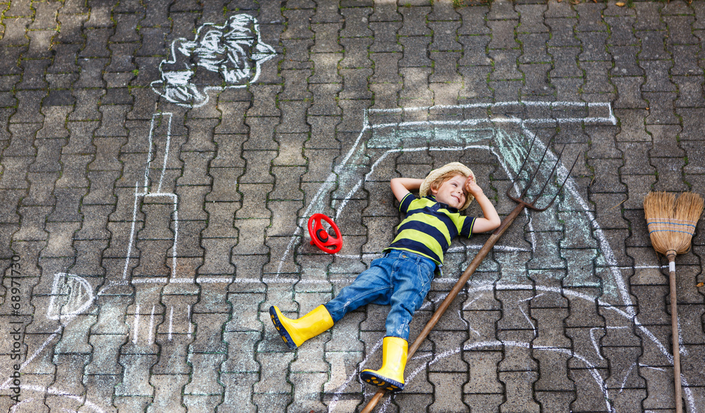 Little boy having fun with tractor picture drawing with chalk Little boy having fun with tractor picture drawing with chalk