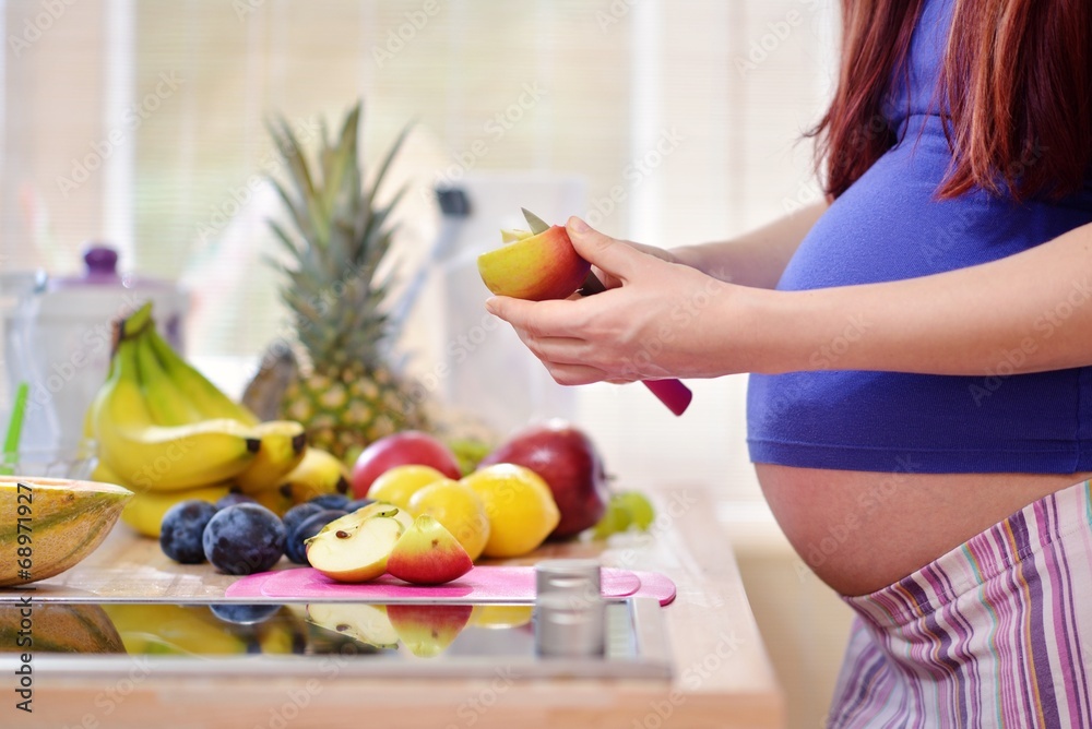 pregnant woman peeling apple